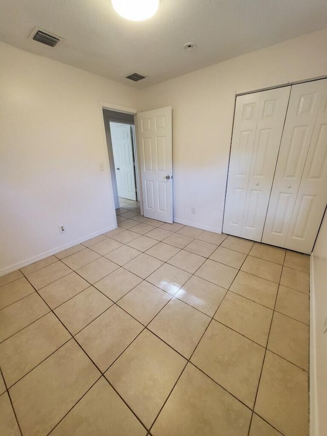 unfurnished bedroom with light tile patterned floors and a closet