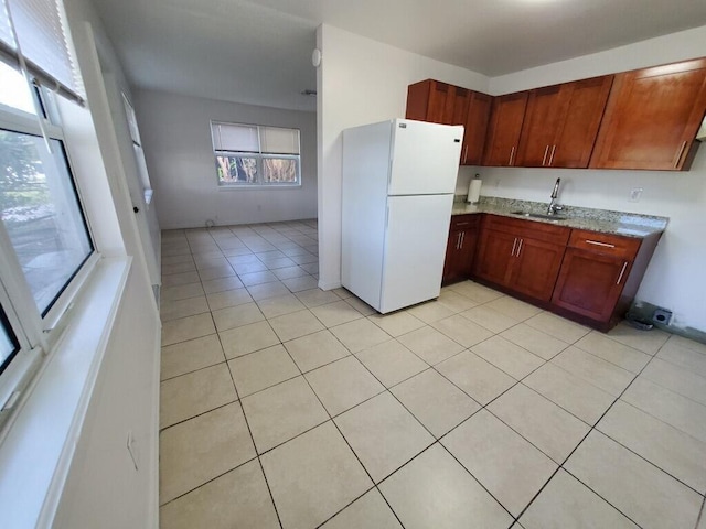 kitchen with sink, light tile patterned flooring, and white refrigerator