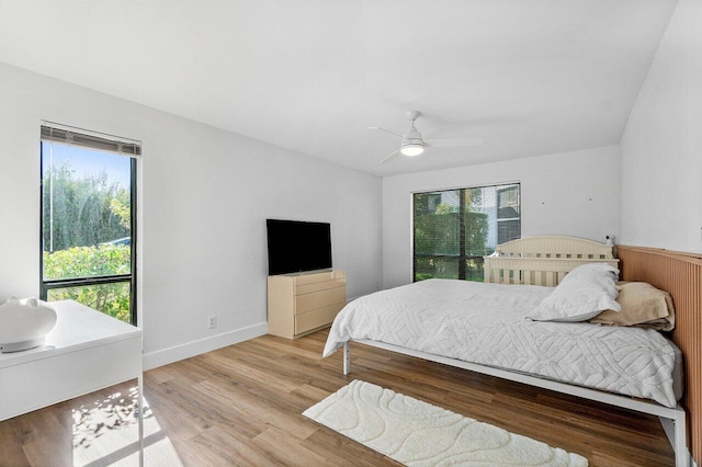 bedroom with hardwood / wood-style flooring, multiple windows, and ceiling fan