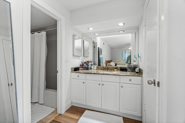 bathroom with wood-type flooring, vanity, and shower / bath combo