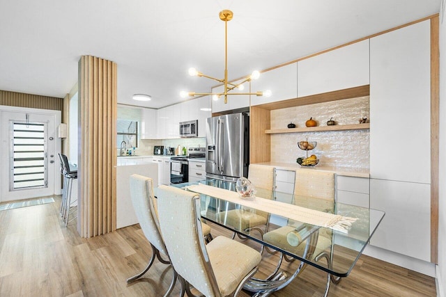 dining room featuring light wood-type flooring and an inviting chandelier