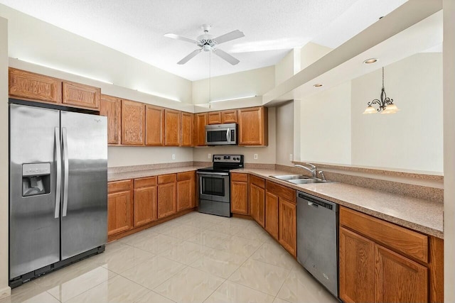 kitchen with sink, hanging light fixtures, a textured ceiling, ceiling fan with notable chandelier, and appliances with stainless steel finishes