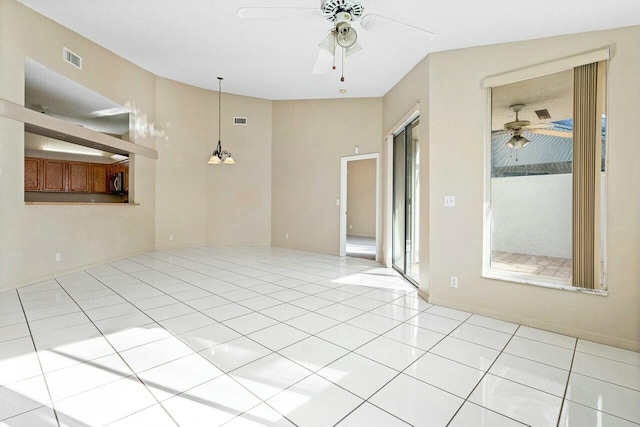 spare room featuring light tile patterned floors, plenty of natural light, and ceiling fan