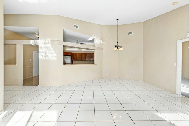 unfurnished living room with ceiling fan with notable chandelier, high vaulted ceiling, and light tile patterned flooring