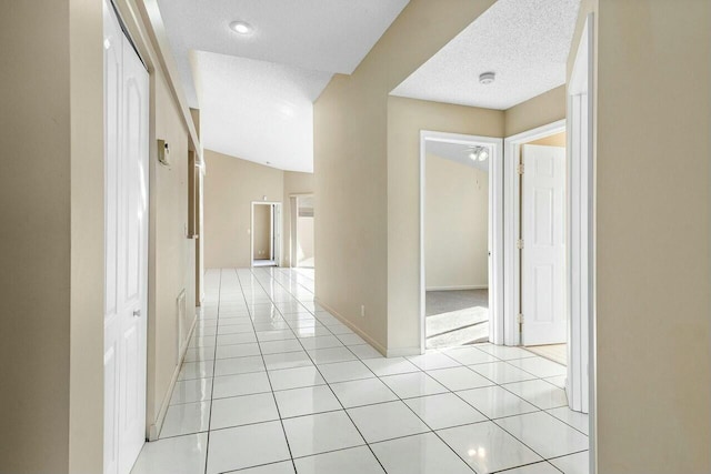 hallway featuring light tile patterned floors and a textured ceiling