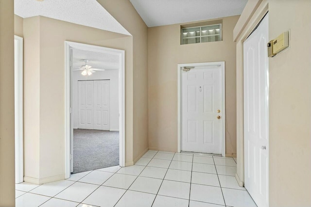 entrance foyer featuring ceiling fan, light tile patterned floors, and a textured ceiling