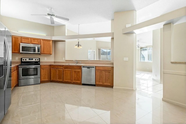 kitchen featuring a textured ceiling, decorative light fixtures, stainless steel appliances, and a chandelier