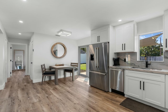 kitchen featuring light hardwood / wood-style floors, white cabinetry, sink, and appliances with stainless steel finishes