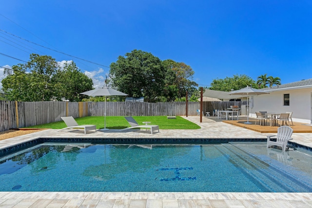 view of swimming pool with a patio, a deck, and a lawn