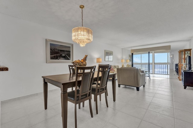 tiled dining area featuring a textured ceiling and an inviting chandelier