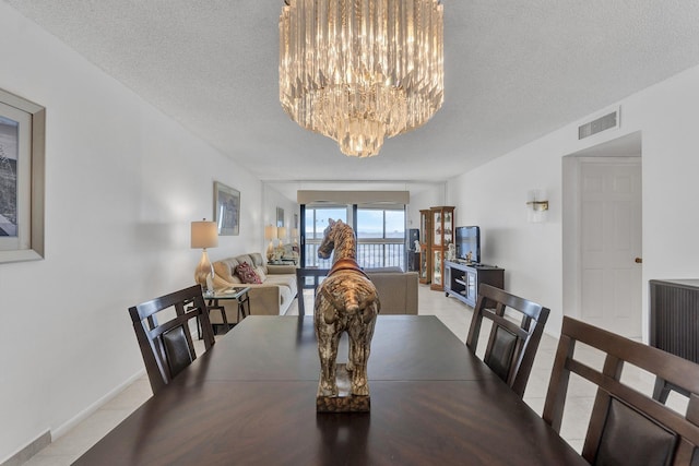 dining area featuring a textured ceiling and a notable chandelier