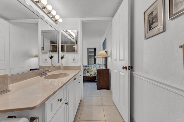 bathroom featuring tile patterned flooring, vanity, and a textured ceiling