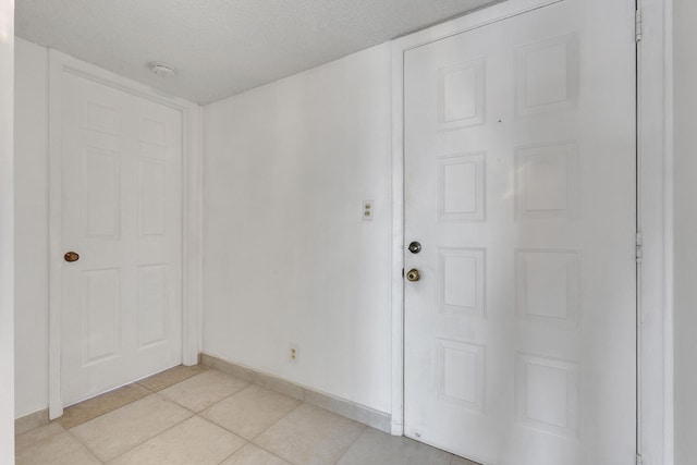 interior space featuring light tile patterned flooring and a textured ceiling