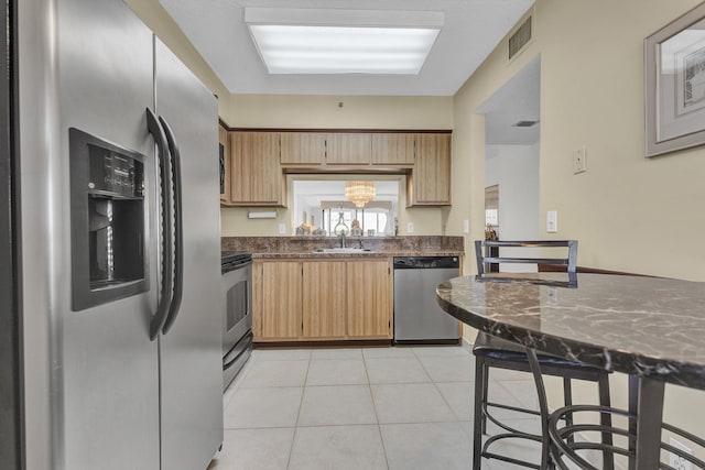 kitchen with light tile patterned flooring, stainless steel appliances, and sink