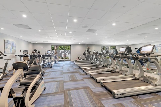 exercise room featuring carpet flooring and a paneled ceiling