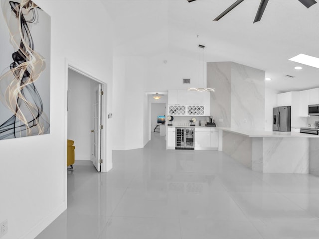 unfurnished living room featuring high vaulted ceiling, wine cooler, ceiling fan, and light tile patterned flooring