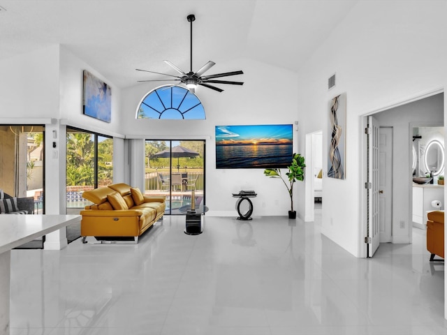 tiled living room featuring ceiling fan and high vaulted ceiling