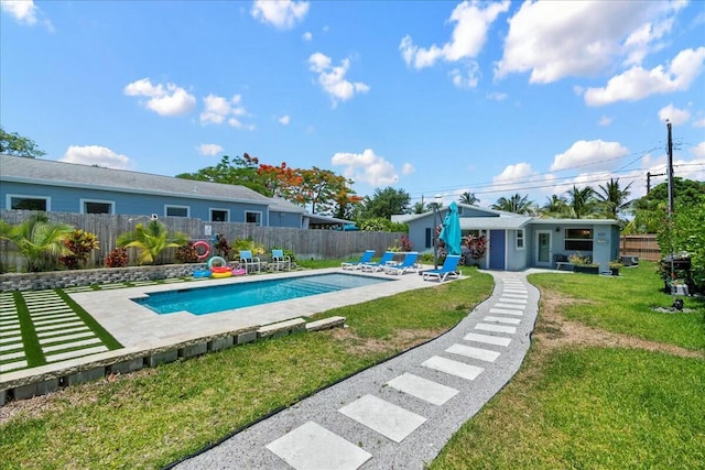 view of pool with a lawn and a patio