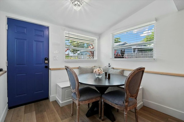 dining area featuring breakfast area, lofted ceiling, and hardwood / wood-style flooring