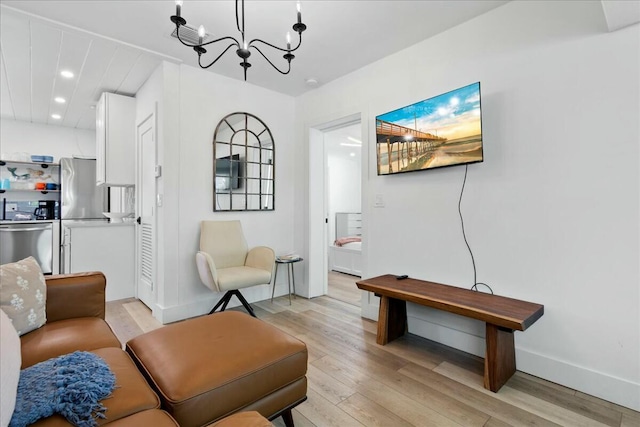 living room with a chandelier and light hardwood / wood-style floors