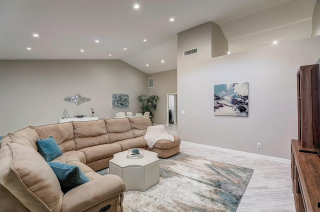 living room with light hardwood / wood-style floors and high vaulted ceiling