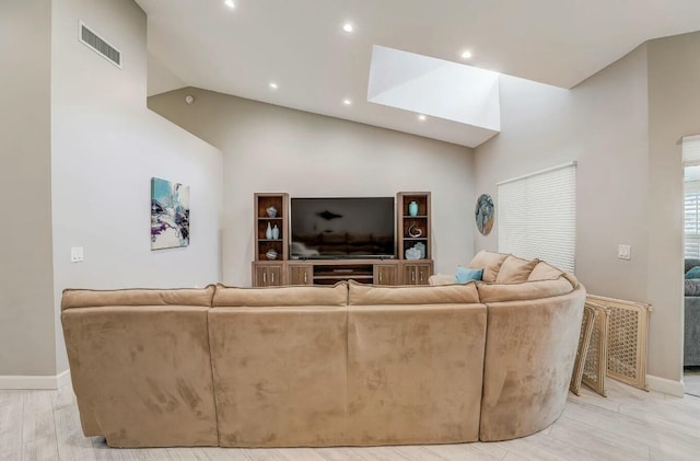 living room with high vaulted ceiling and light hardwood / wood-style floors