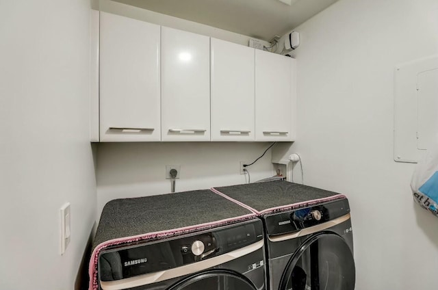 washroom with cabinets, separate washer and dryer, and electric panel