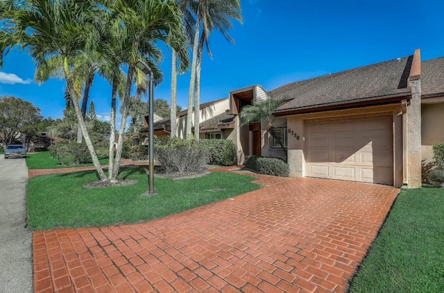 ranch-style home with a garage and a front yard