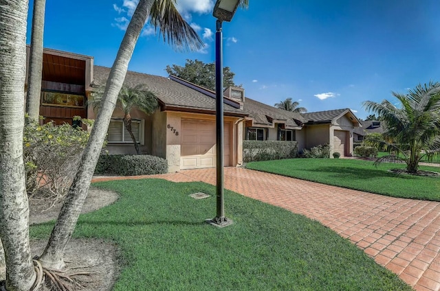 view of front of house with a garage and a front lawn