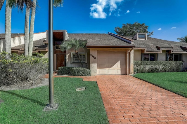 ranch-style house featuring a garage and a front lawn