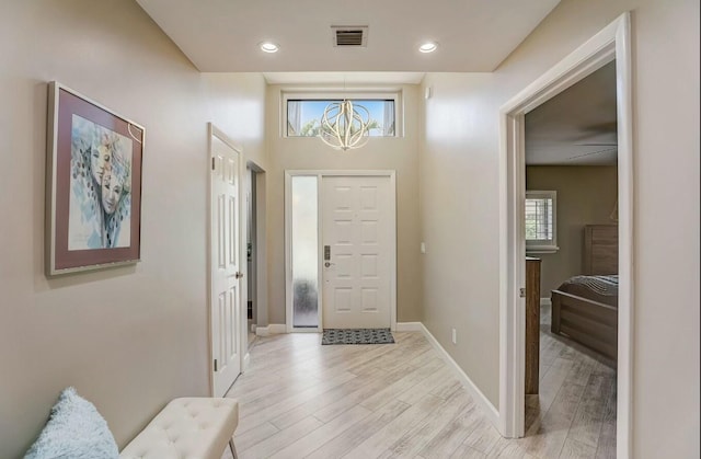 entrance foyer with light hardwood / wood-style flooring and a notable chandelier