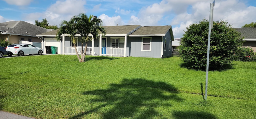 ranch-style home with a front yard, a porch, and a garage