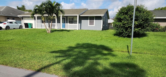 ranch-style house featuring a garage, covered porch, and a front yard