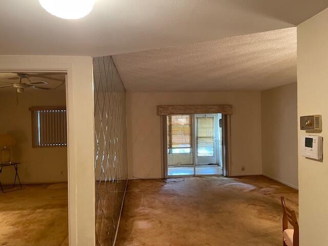 unfurnished room featuring ceiling fan and a textured ceiling