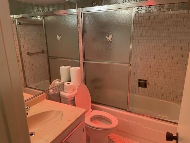 full bathroom featuring vanity, toilet, and enclosed tub / shower combo