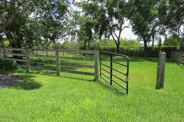 view of gate with a lawn