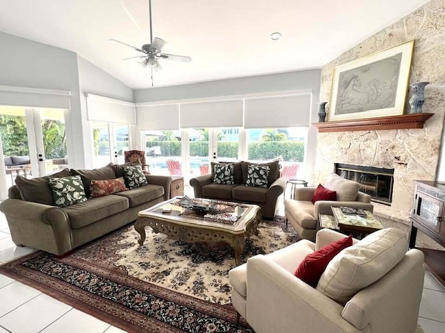 tiled living room featuring a fireplace, french doors, a wealth of natural light, and ceiling fan