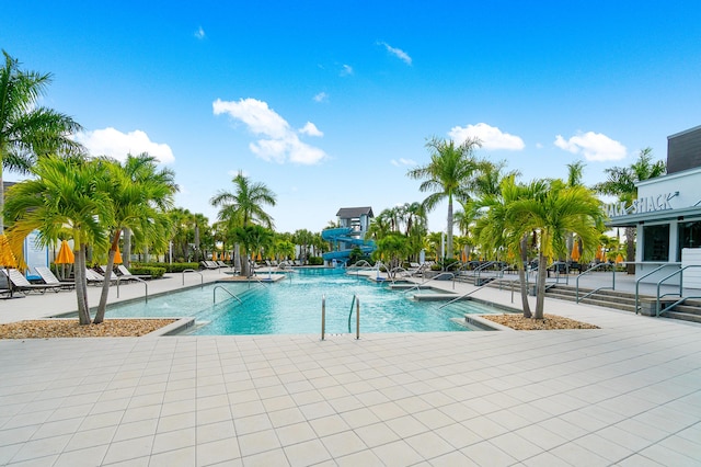 view of swimming pool with a patio area and a water slide