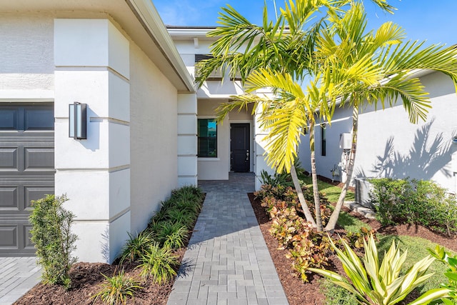 entrance to property featuring cooling unit and a garage