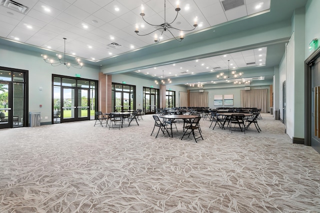 carpeted dining space featuring french doors, a towering ceiling, and plenty of natural light