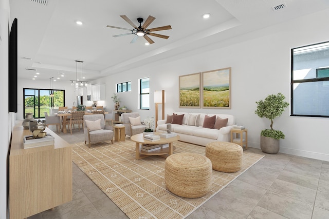 living room with ceiling fan and a tray ceiling