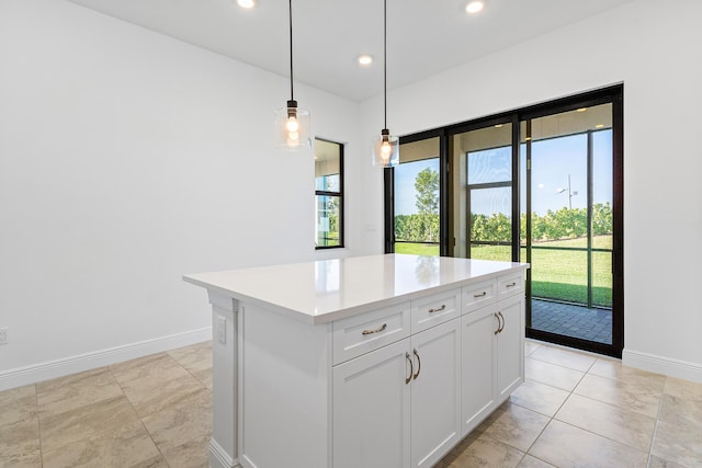 kitchen with white cabinets, a center island, a healthy amount of sunlight, and hanging light fixtures