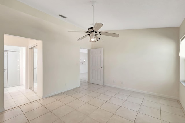 tiled empty room featuring vaulted ceiling and ceiling fan