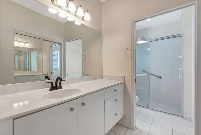 bathroom featuring tile patterned flooring, vanity, toilet, and walk in shower