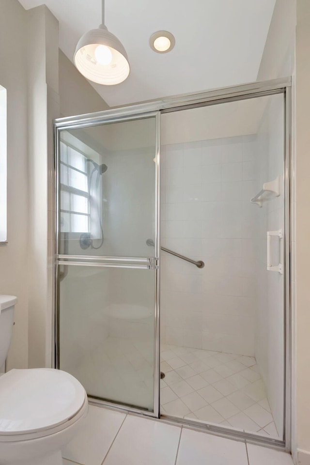 bathroom with toilet, tile patterned floors, and an enclosed shower