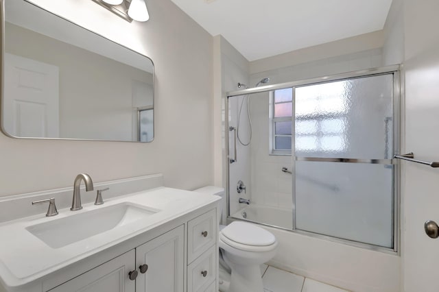 full bathroom featuring shower / bath combination with glass door, tile patterned flooring, vanity, and toilet