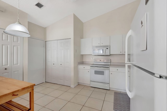 kitchen featuring white cabinetry, vaulted ceiling, decorative light fixtures, white appliances, and light tile patterned flooring