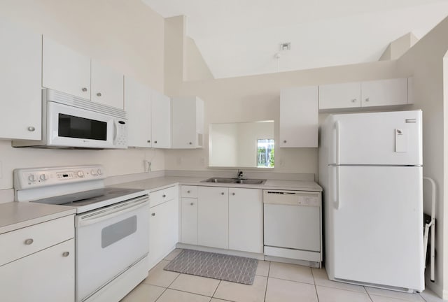 kitchen featuring white cabinetry, sink, a towering ceiling, white appliances, and light tile patterned flooring