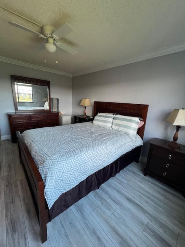 bedroom with ceiling fan, hardwood / wood-style floors, crown molding, and a textured ceiling