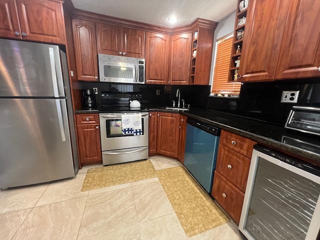 kitchen featuring sink, beverage cooler, stainless steel appliances, backsplash, and light tile patterned floors